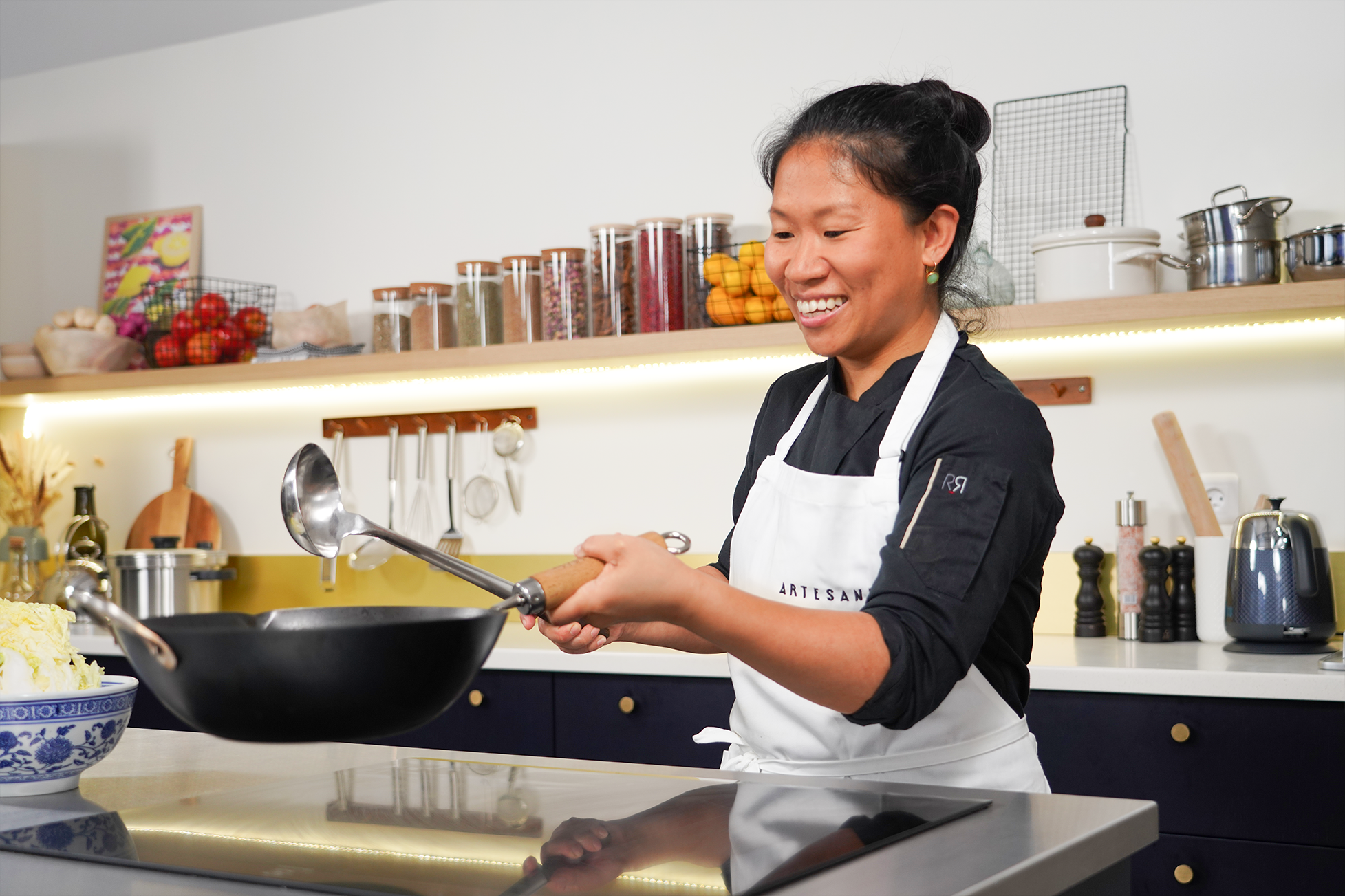 la cheffe Lucy Chen utilisant un wok dans son cours de cuisine chinoise sur Artesane.