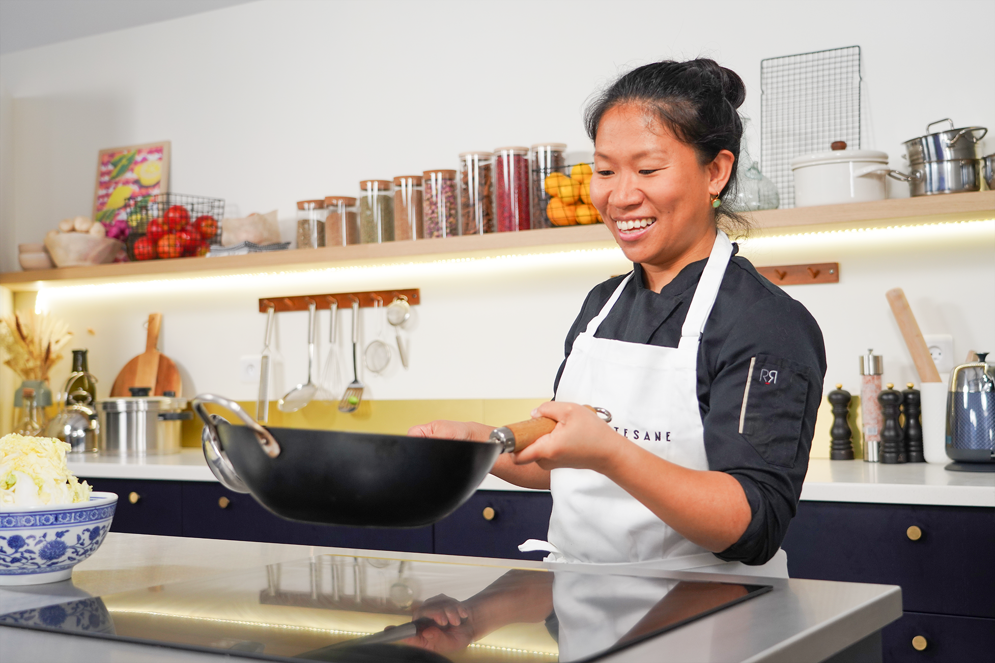 la cheffe Lucy Chen utilisant un wok dans son cours de cuisine chinoise sur Artesane.