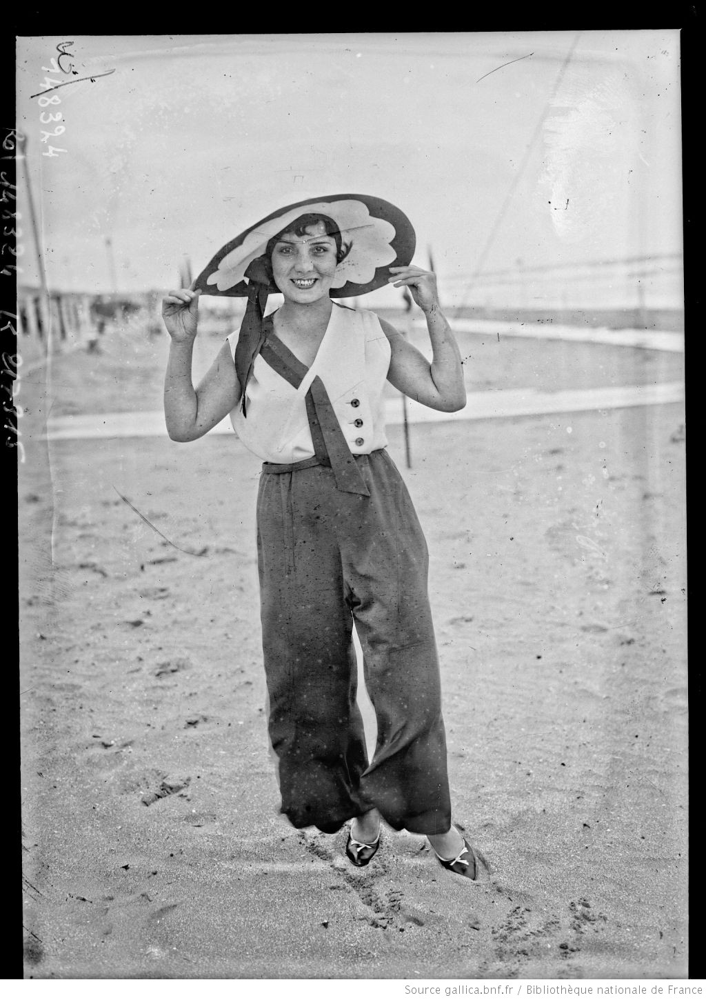 photo d'une femme en pantalon sur la plage dans les années 1920